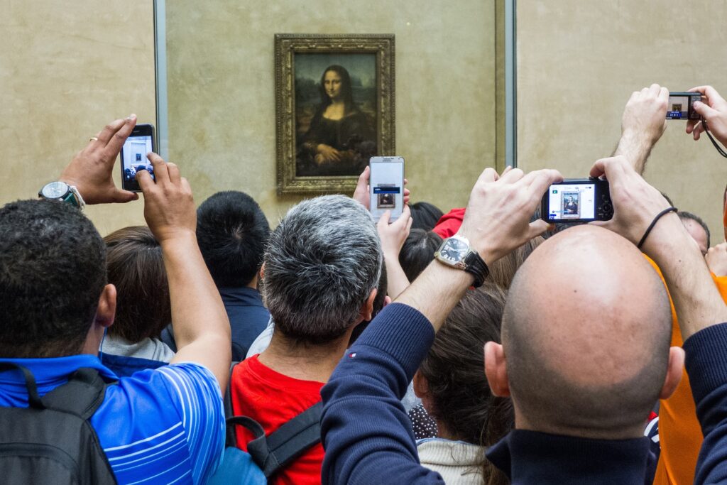 Esperienze visive uniche 9 la gente si accalca di frornte alla teca della Monnalisa non per vederla ma per scattare una foto ricordo
